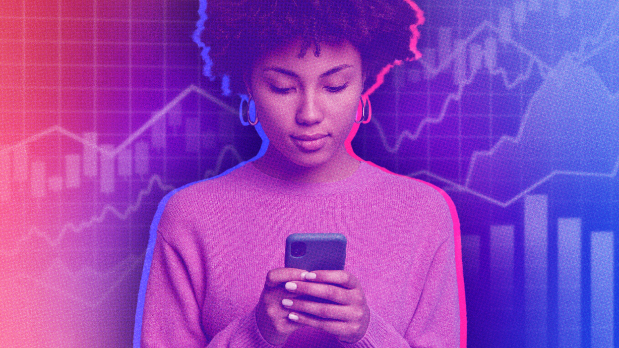 Woman looking at phone against stock market background