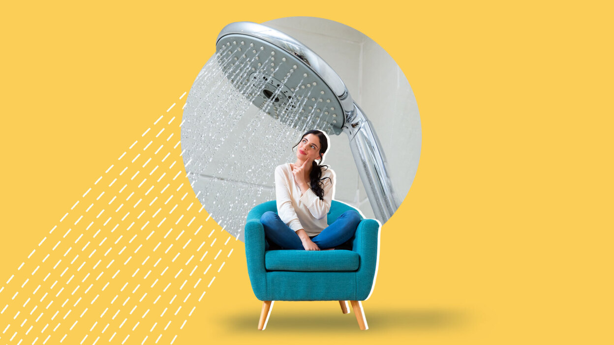 A woman sitting under a showerhead