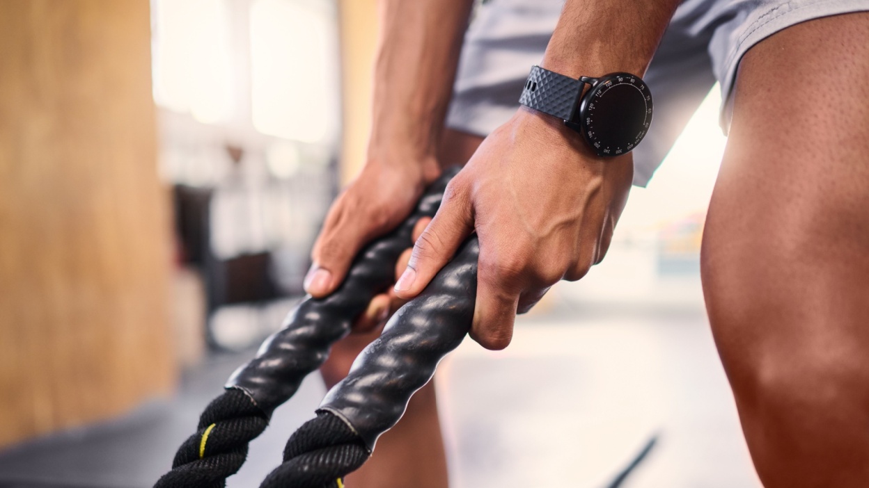 man holding a rope attachment in the gym