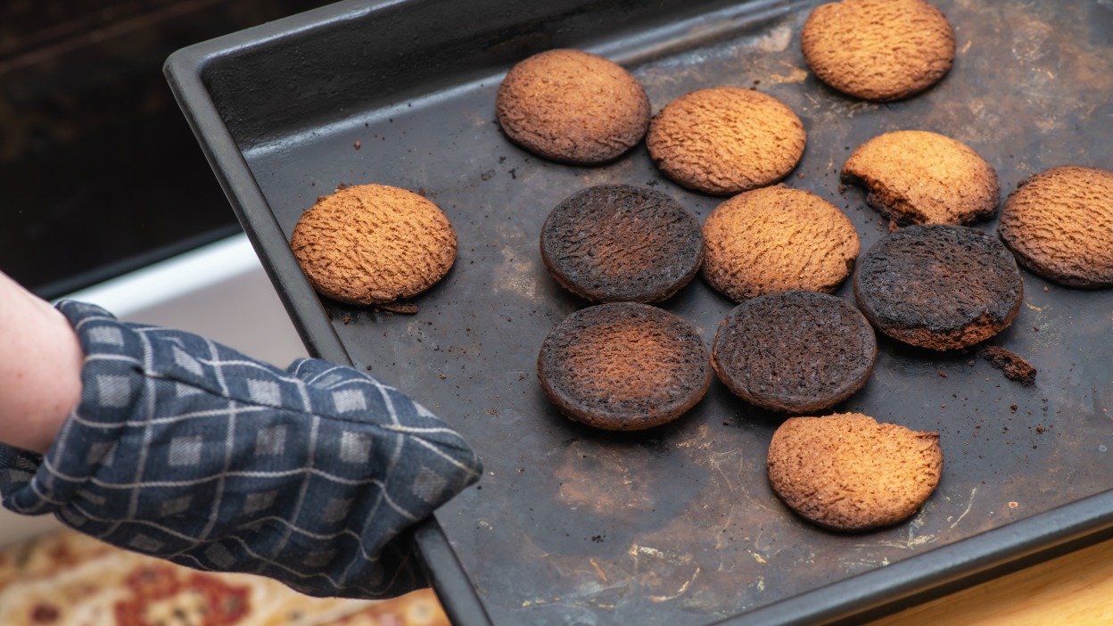 Cookies with burnt bottoms on a sheet tray.