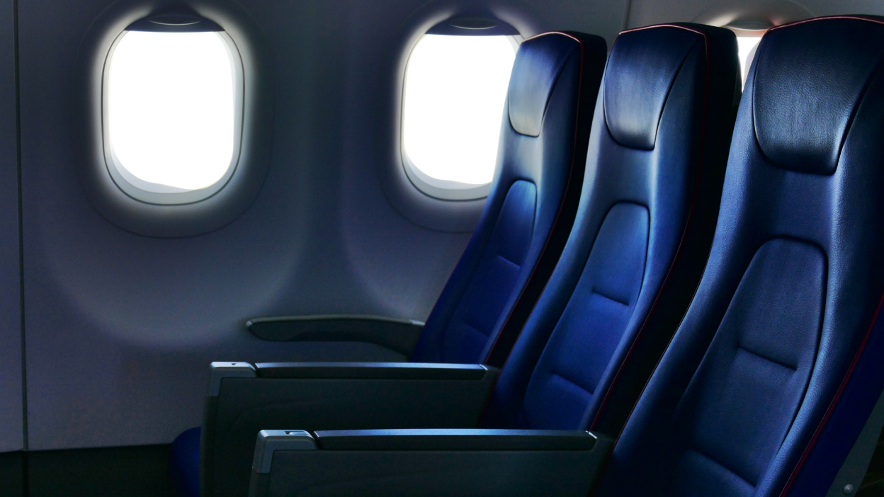 A row of economy/coach seats on an airplane