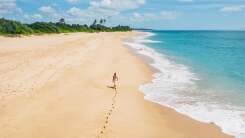 young woman taking a long walk on a beach