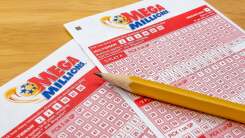 two blank mega millions lottery tickets with a sharpened pencil