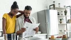 A couple reads a newspaper and exchanges ideas