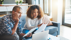 Finance, budget and banking with a young couple feeling stress, anxiety and worry about savings, investment and the future. Boyfriend and girlfriend planning and talking about bills, taxes and debt