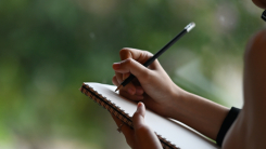 Woman writing notes next to window