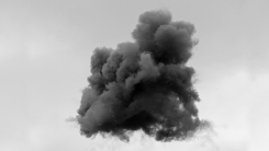 An ominous, smoky black cloud against a gray sky