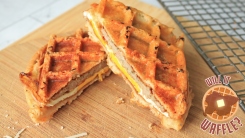 Sausage, egg, and cheese sandwich cut in half on a cutting board.