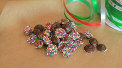 Nonpareil candies on a table with Christmas ribbon nearby