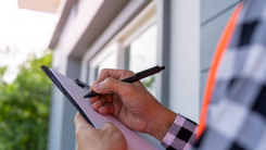 Home inspector holding a clipboard and a pen