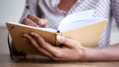 person writing in a journal