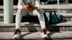 woman looking at phone, getting ready for a workout