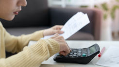 Woman calculating bill with calculator