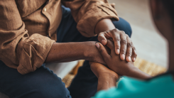 Closeup shot of a young woman holding a senior man's hands in comfort