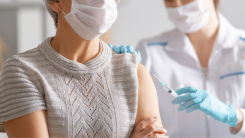 An elderly person getting a vaccine administered by a doctor