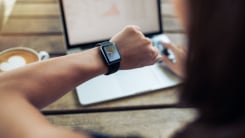 woman looking at watch at cafe