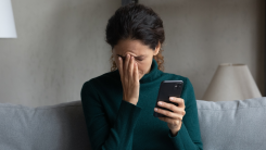 Woman reacting to bad news on her phone.