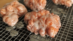 Apple fritters drying on a wire rack.