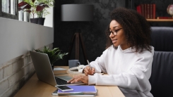 Young woman taking notes from laptop