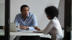 man and woman sitting at a table talking