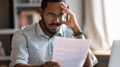 Frustrated man looking at paperwork