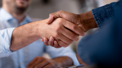 A close-up photograph of two people shaking hands