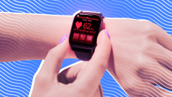 A closeup of a smartwatch on a wrist displaying heart rate data