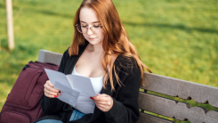 Student on bench reading letters