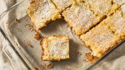 Gooey butter cake cut in squares in a baking dish.