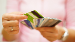 Woman choosing from spread of credit cards.