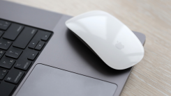 A MacBook with a Magic Mouse resting on top of it