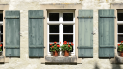 outside view of a cottage window with shutters on a home