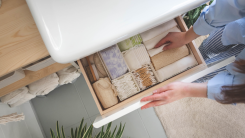 person opening drawer to organize items with several containers