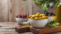 Three bowls of different color olives