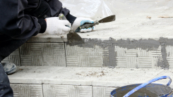 Tiler glosses over gaps between the stacked stone tiles on steps