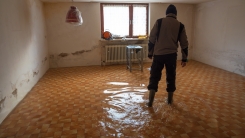 Man walking through flooded basement 