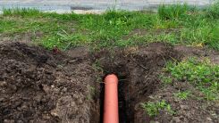 A dug up buried water pipe in a yard