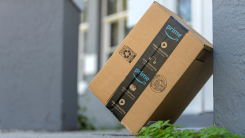 Amazon Prime package box with purchased online products delivered in front of house door. 