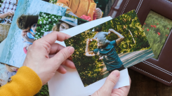 Hands holding a small pile of printed four-by-six photographs