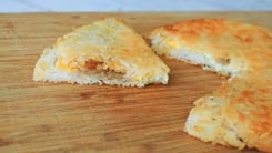 A slice of fried rice cake on a cutting board.