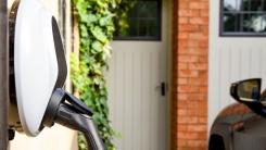 Electric car plugged in to charge outside home