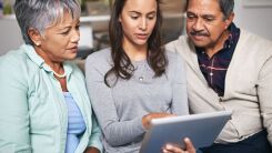 Two older parents following along as their daughter shows them something on a tablet