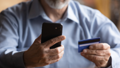 Close up of man holding cell phone and credit card