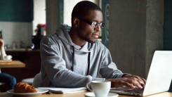 Young professional focusing on laptop.