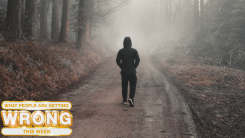 single boy walking through a forest landscape in a country footpath