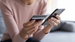 woman holding a credit card and smartphone