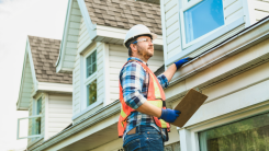 home inspector looking at roof of a house