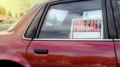 for sale sign in window of a used red car