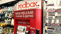 A Redbox kiosk in a convenience store aisle