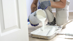 man pouring paint into tray 